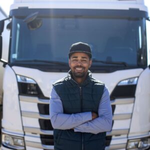 Truck driver smiling in front of his truck cab