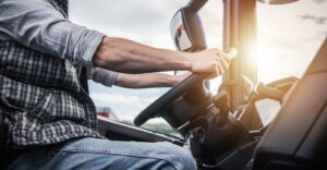 Closeup of a truck driver holding the steering wheel